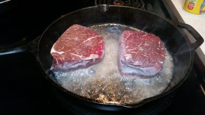 Разморозить мясо в горячей воде. Стейк замороженный мясо. Мороженое мясо оттаивают.